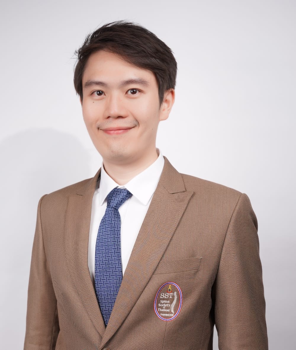 กระดูกสันหลัง กรรมการบริหารใส่สูทสีน้ำตาลอ่อน พร้อมเข็มกลัด SST Spine Society Thailand ออร์โธปิดิกส์