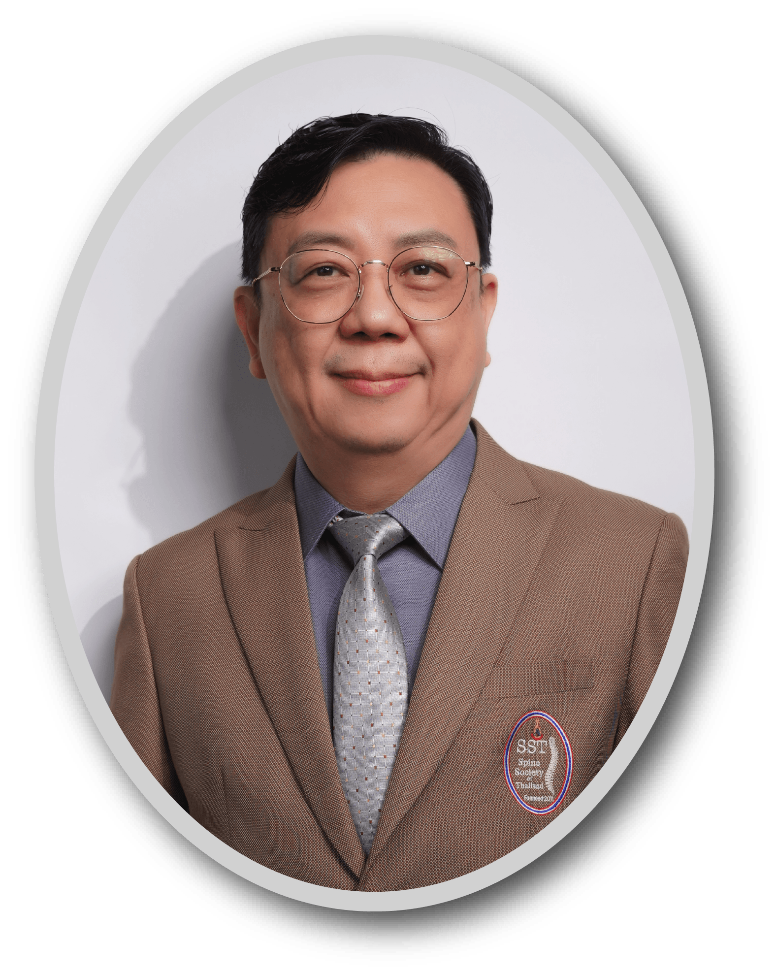 Man in brown suit jacket with Spine Society of Thailand logo, wearing gray shirt and patterned tie