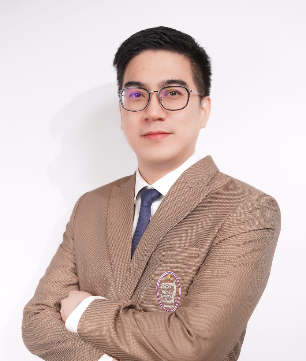 กระดูกสันหลัง กรรมการบริหารปัจจุบัน สวมสูทสีน้ำตาล ยืนกอดอก ออร์โธปิดิกส์