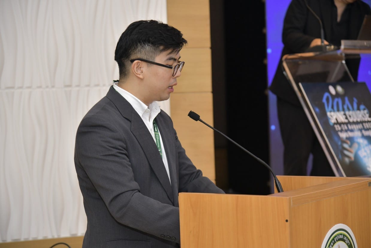 กระดูกสันหลัง ชายเอเชียกำลังพูดที่โพเดียมในงานประชุม BASIC SPINE COURSE 2025 ออร์โธปิดิกส์