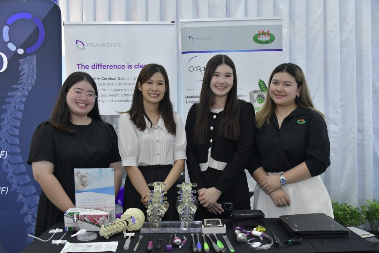 กระดูกสันหลัง ภาพจากงานประชุมวิชาการ BASIC SPINE COURSE 2025: ผู้หญิงสี่คนยืนอยู่หน้าบูธแสดงสินค้าเกี่ยวกับกระดูกสันหลัง ออร์โธปิดิกส์