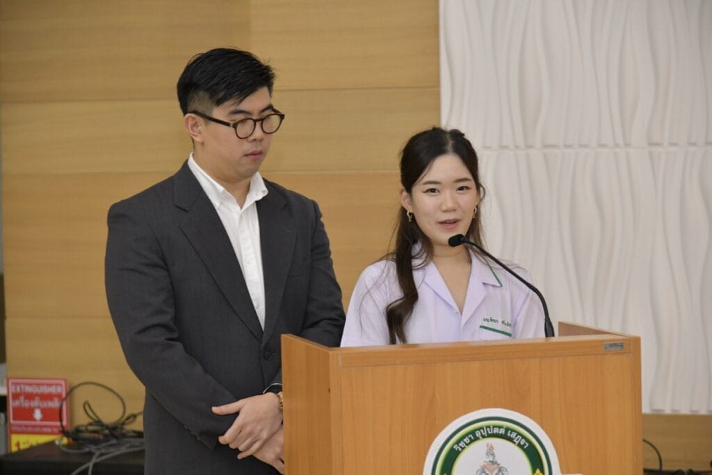 กระดูกสันหลัง งานประชุมวิชาการ BASIC SPINE COURSE 2025: ผู้ชายในชุดสูทและผู้หญิงในชุดพยาบาลพูดที่โพเดียม ออร์โธปิดิกส์