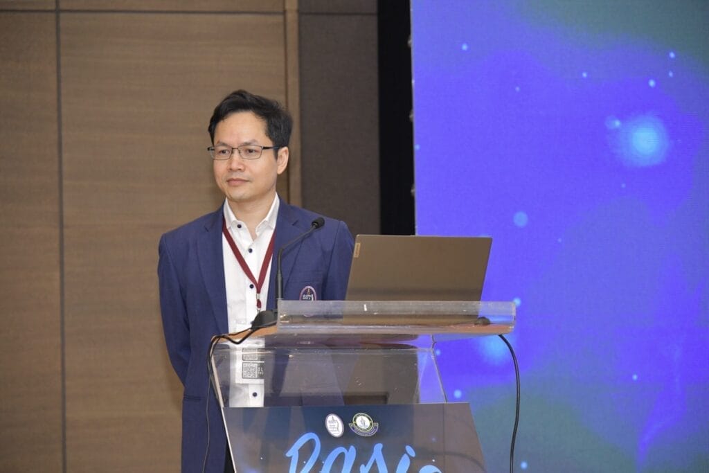 กระดูกสันหลัง ผู้ชายยืนอยู่หลังโพเดียมในงานประชุมวิชาการ BASIC SPINE COURSE 2025 ออร์โธปิดิกส์