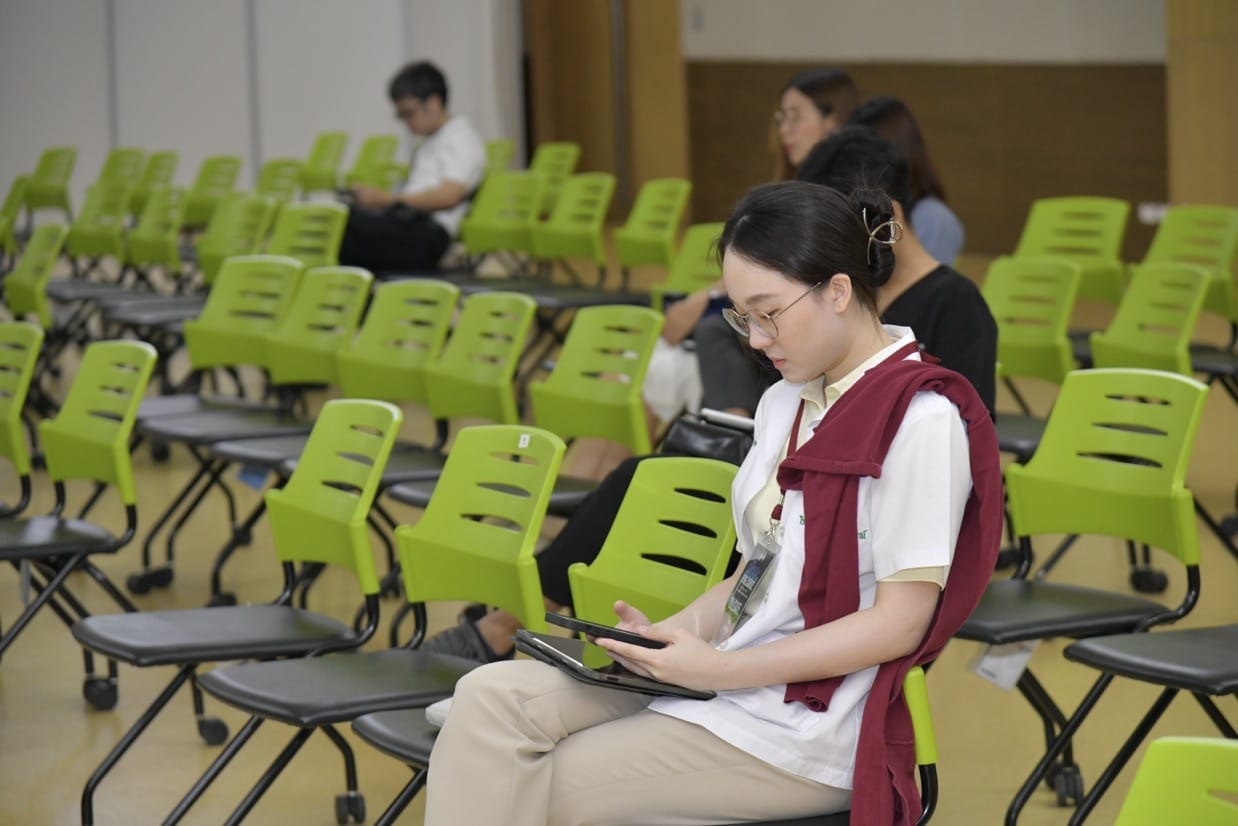 กระดูกสันหลัง ผู้เข้าร่วมประชุม BASIC SPINE COURSE 2025 กำลังดูแท็บเล็ต นั่งบนเก้าอี้สีเขียว ออร์โธปิดิกส์
